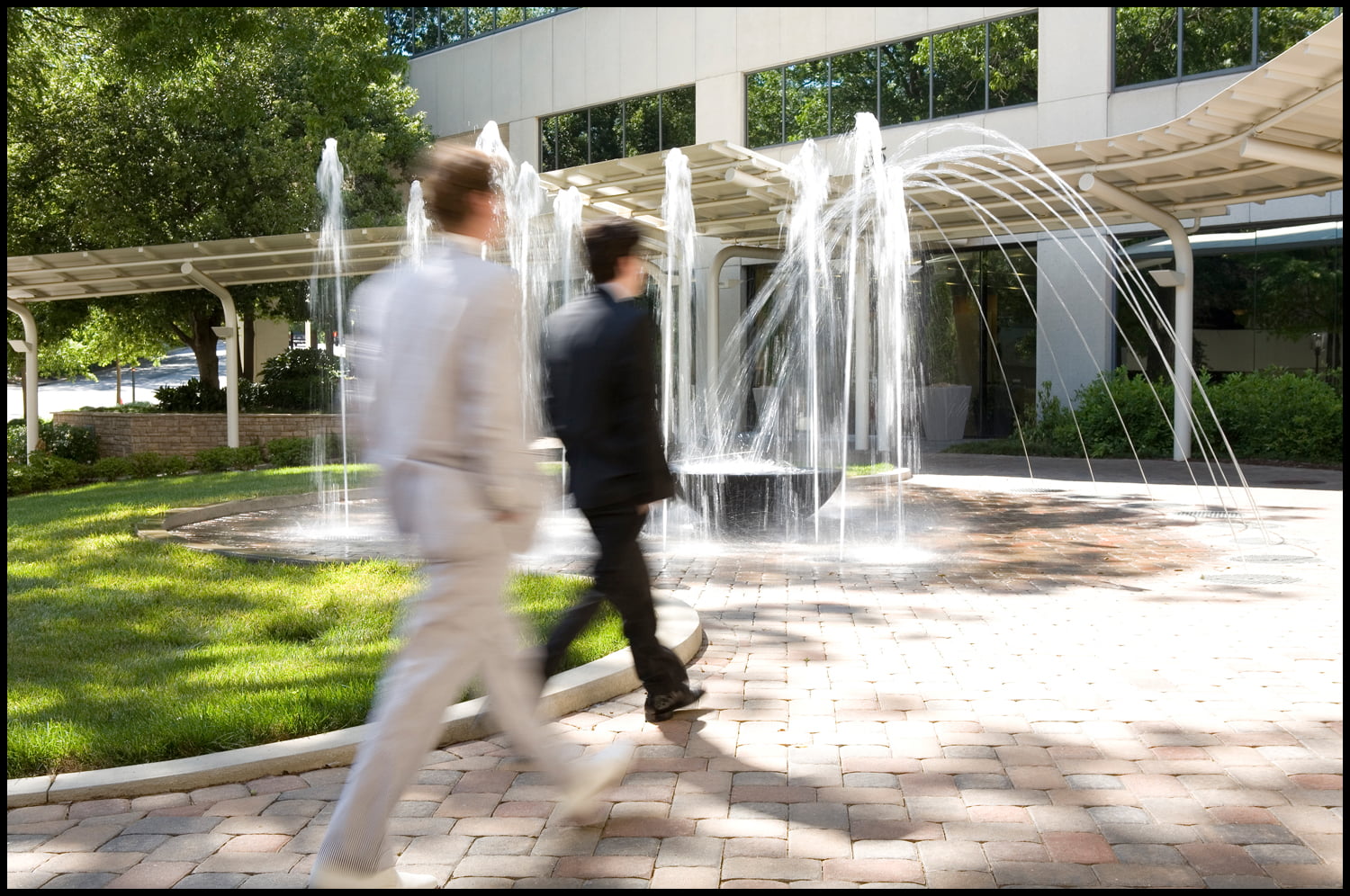 Workers walking in front of fountain
