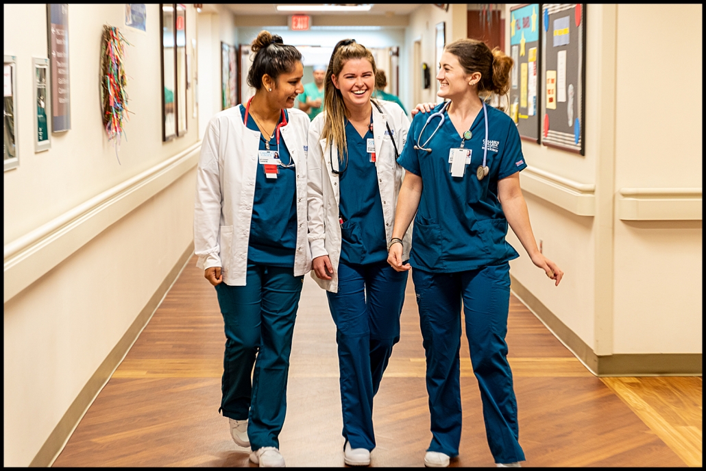 Healthcare photography - 3 smiling nurses walking down a hospital hallway