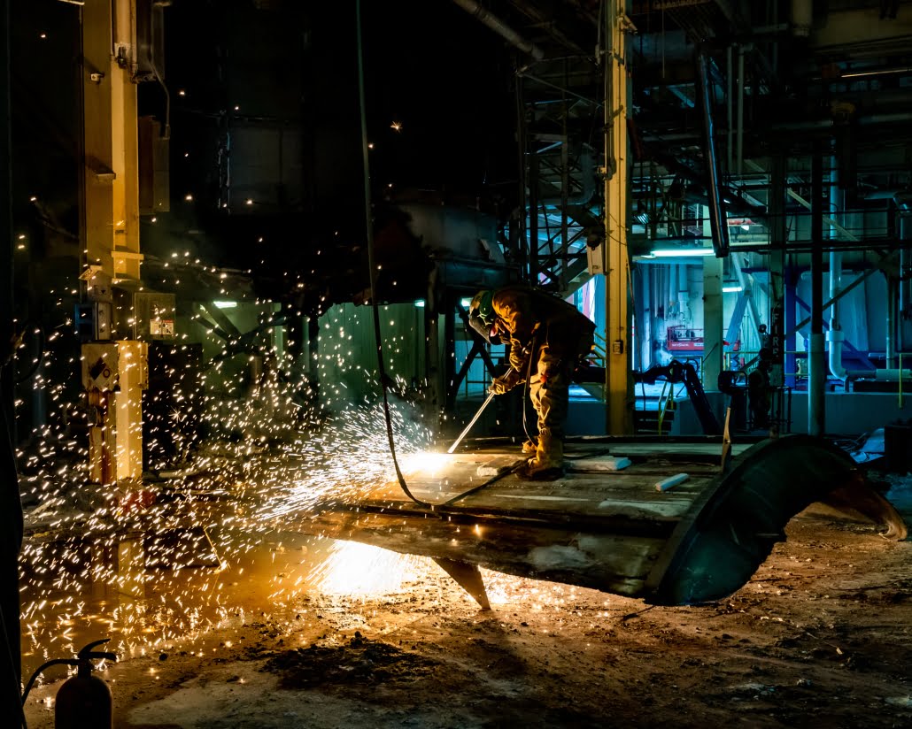 Industrial Photography - Worker cutting metal tank