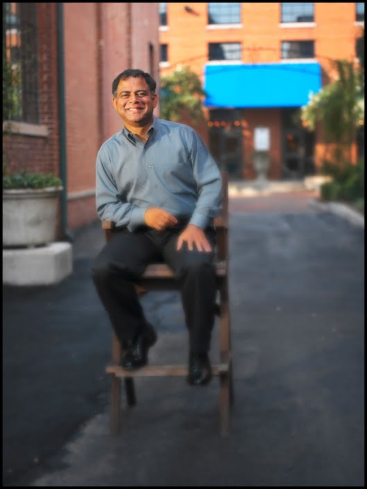 Michael LoBiondo Photography - environmental portrait of small business owner sitting in chair between buildings