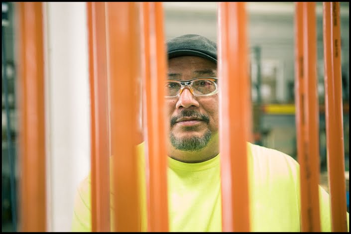 Michael LoBiondo Photography - Working in plant looking through orange metal rods in manufacturing plant