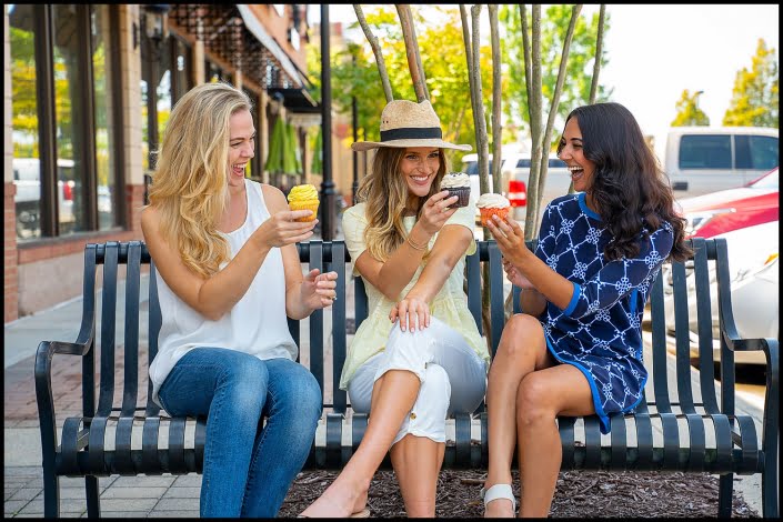 Michael LoBiondo Photography - Young women sharing cupcakes sitting in retail center