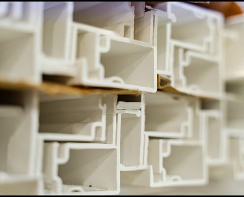 lobiondo-industrial-manufacturing-glass-windows Close-up of stacked PVC window frame profiles in factory