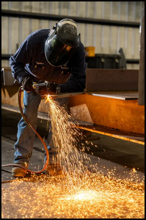 lobiondo-industrial-steel-fab-0712 Steel fabrication worker cutting structural steel in an industrial facility