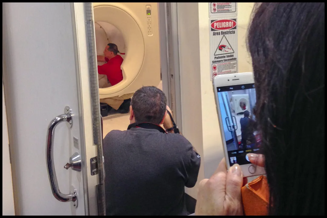 Behind the scenes of a medical photography shoot showing a photo Behind the scenes of a medical photography shoot showing a photographer capturing an MRI imaging maintenance.