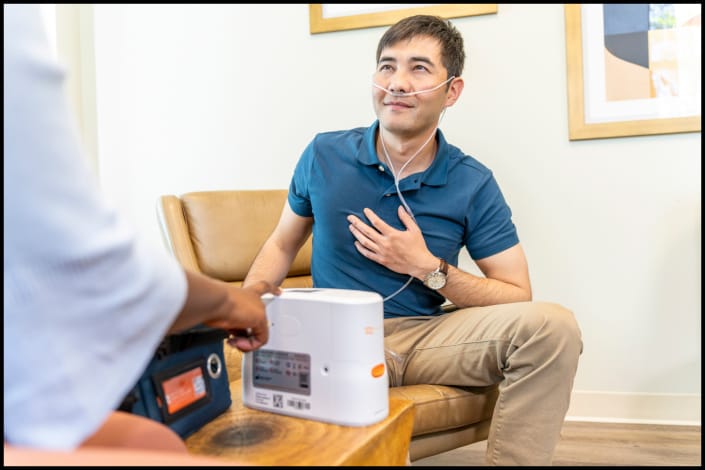 Healthcare professional explaining portable oxygen concentrator