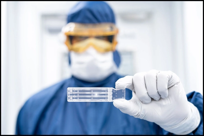 pharmaceutical-cleanroom-medical-device-product-photography-0954 Pharmaceutical cleanroom technician holding a medical device component